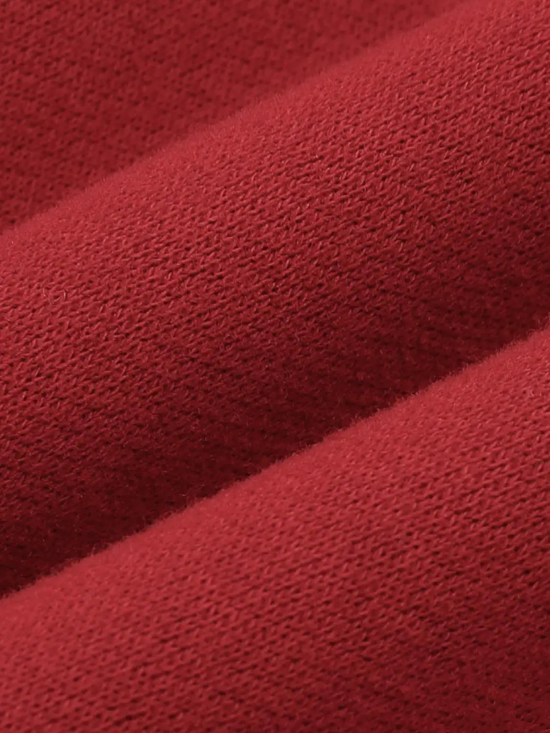 Sweatshirt fabric close-up in red knit texture showing even, soft loops.