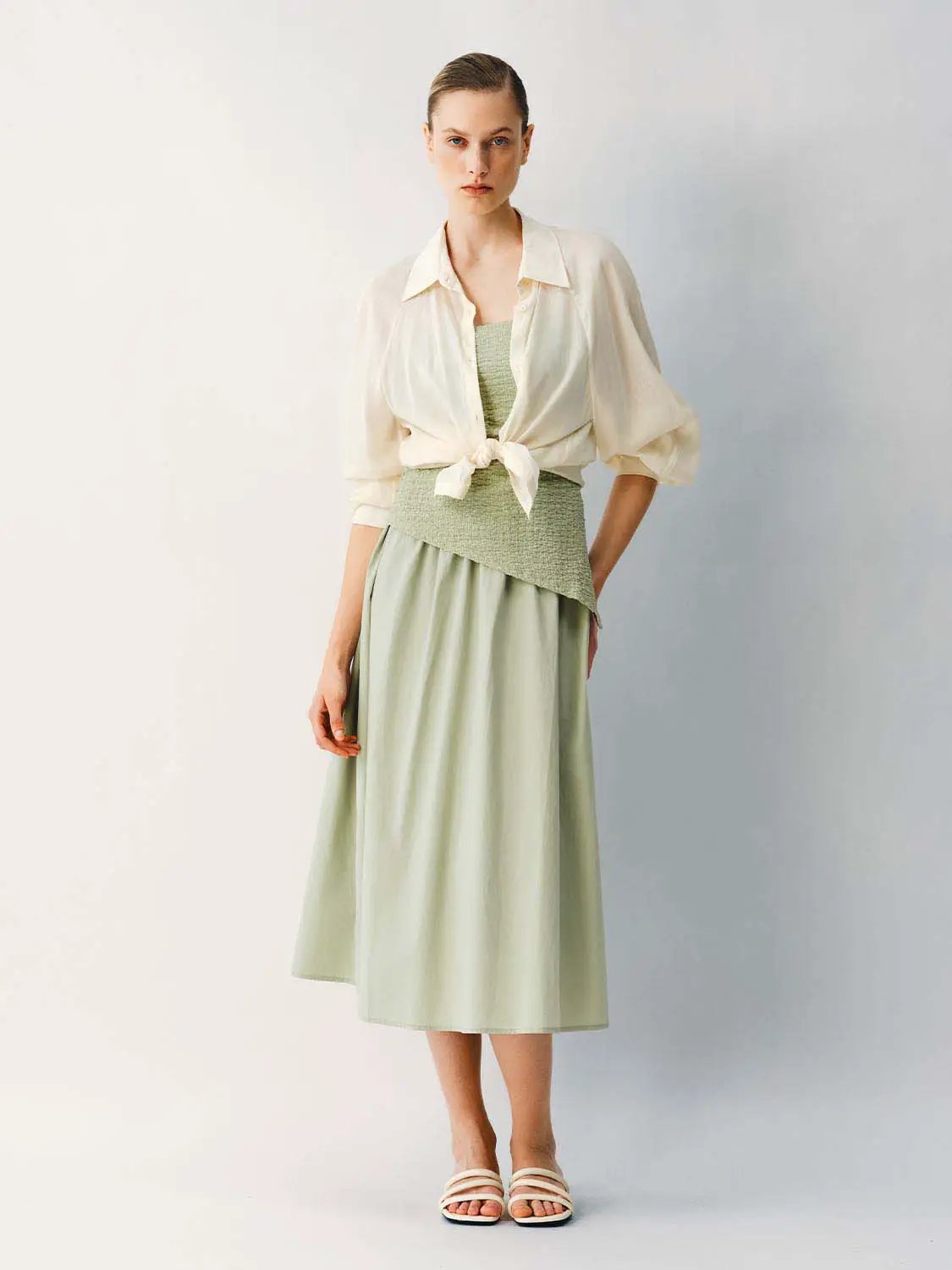 Thin stretch fabric strappy A-line mint-green midi dress worn with a cream blouse