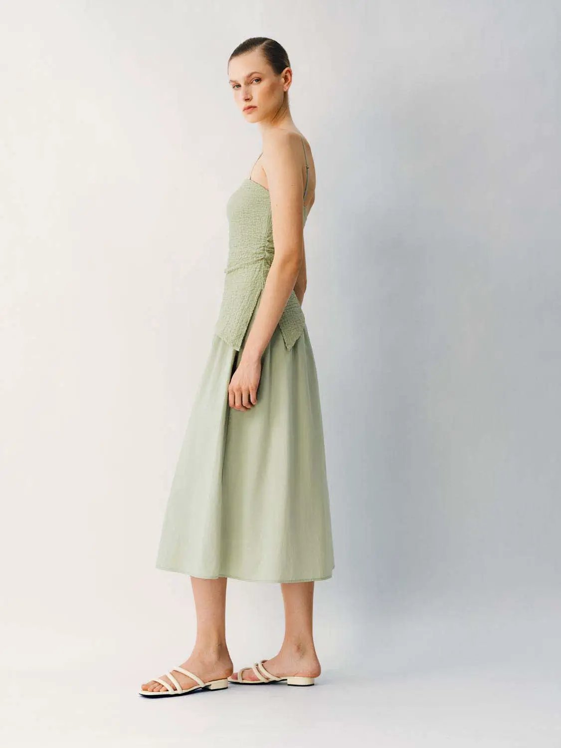 Thin Stretch Fabric Strappy A-Line Midi Dress in sage green on model; ruched bodice, spaghetti straps.