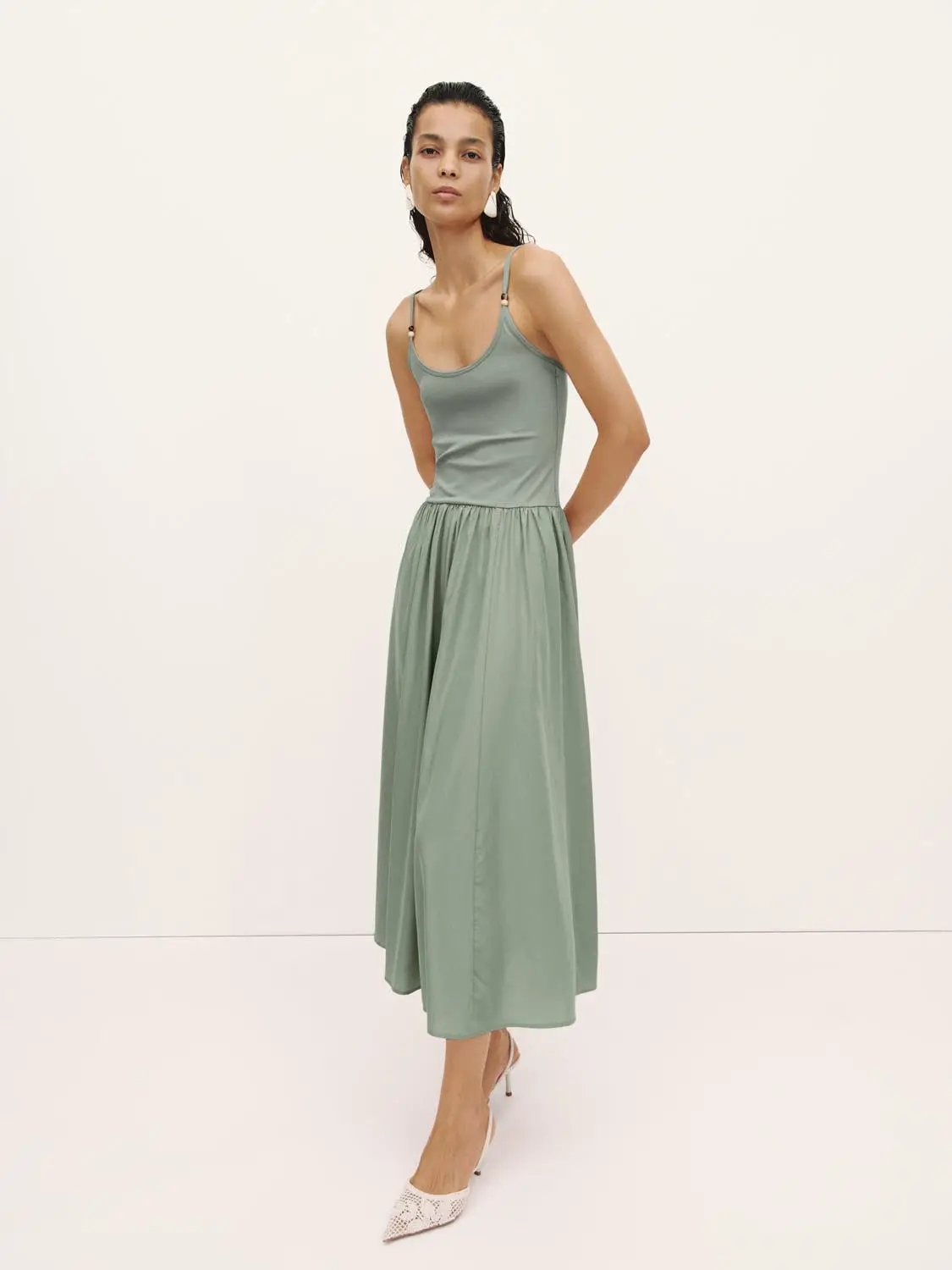 A-line dress in sage green with spaghetti straps and gathered waist, ankle-length.