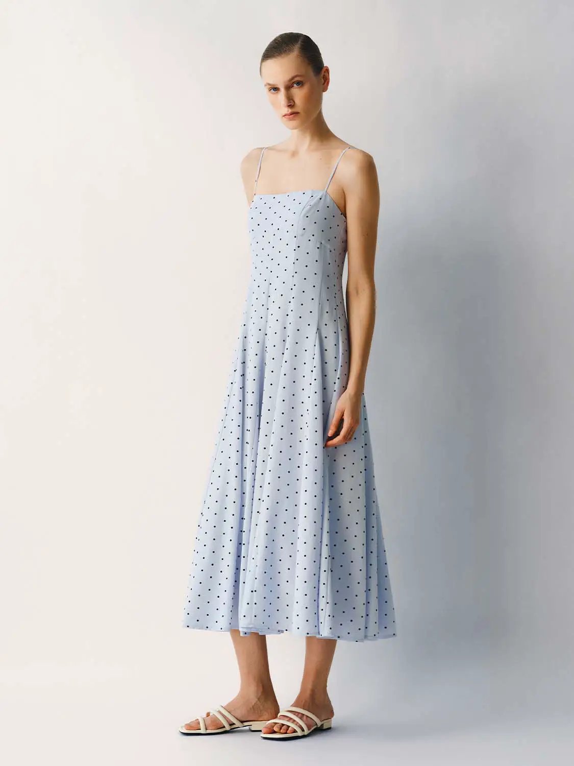 Polka dot A-line dress in light blue with thin spaghetti straps, midi length.