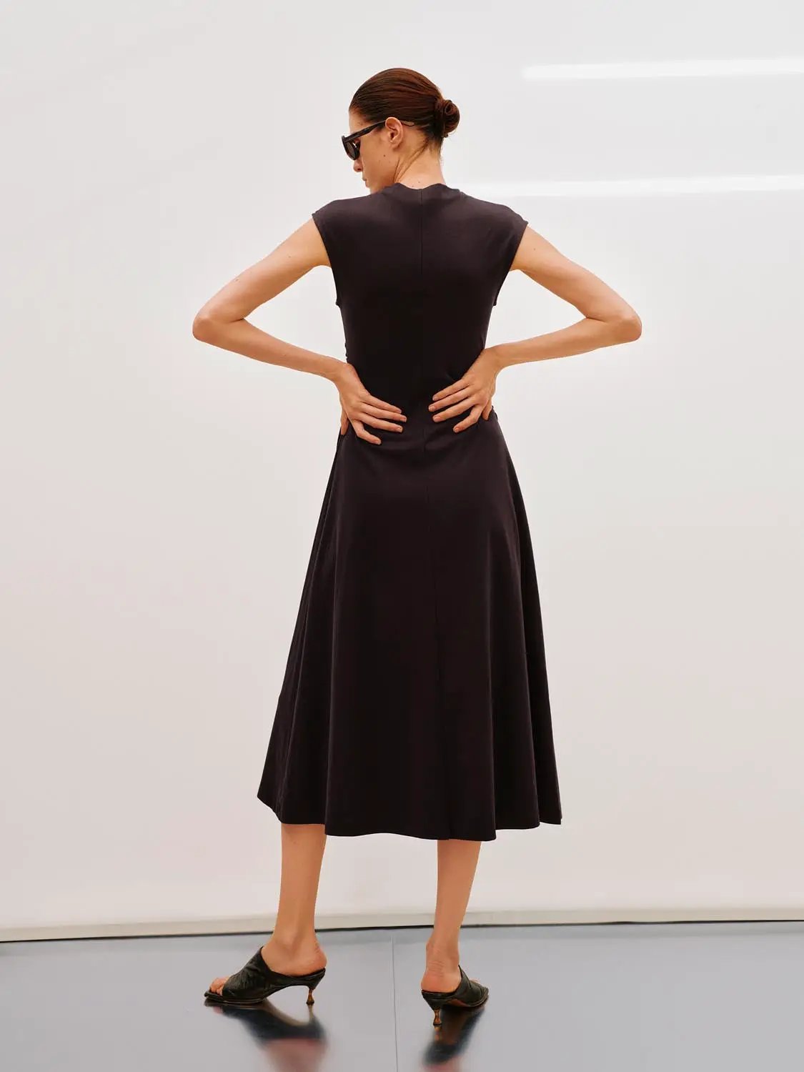 A-Line dress in black, midi-length with short sleeves shown from the back on a model