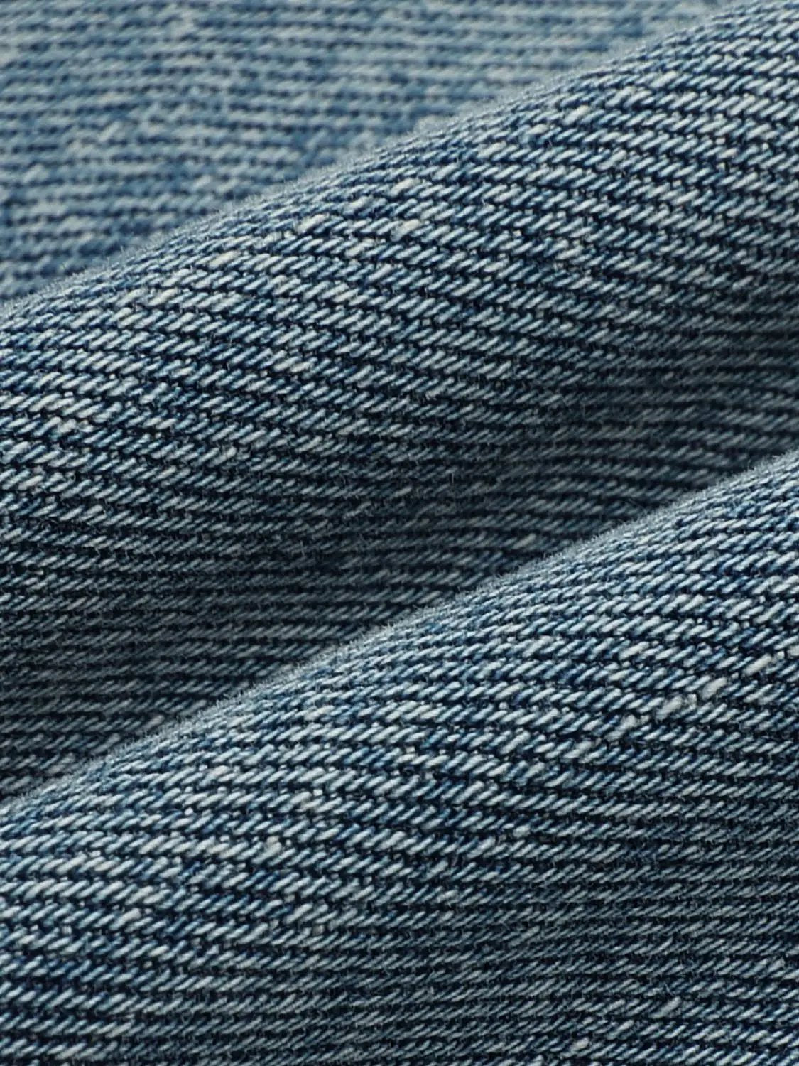 Jeans fabric close-up in blue denim with twill weave texture
