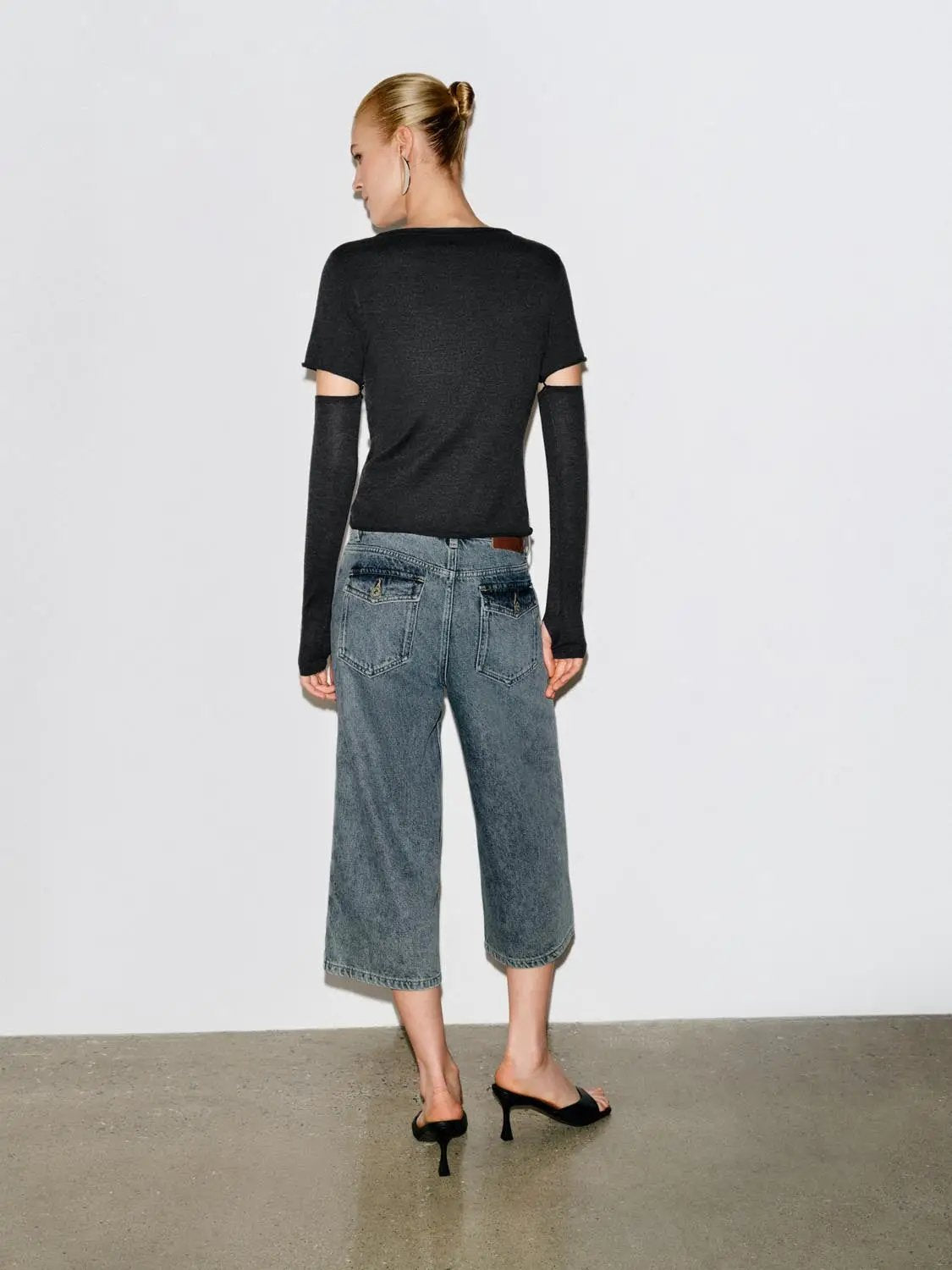 Relaxed high-rise wide-leg Capri cotton jeans in blue denim, back view on model showing cropped length