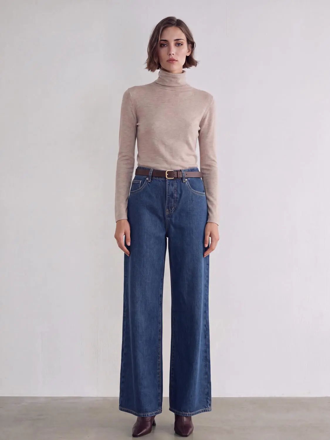 Jeans, blue wide-leg denim with a brown belt, full-length silhouette.