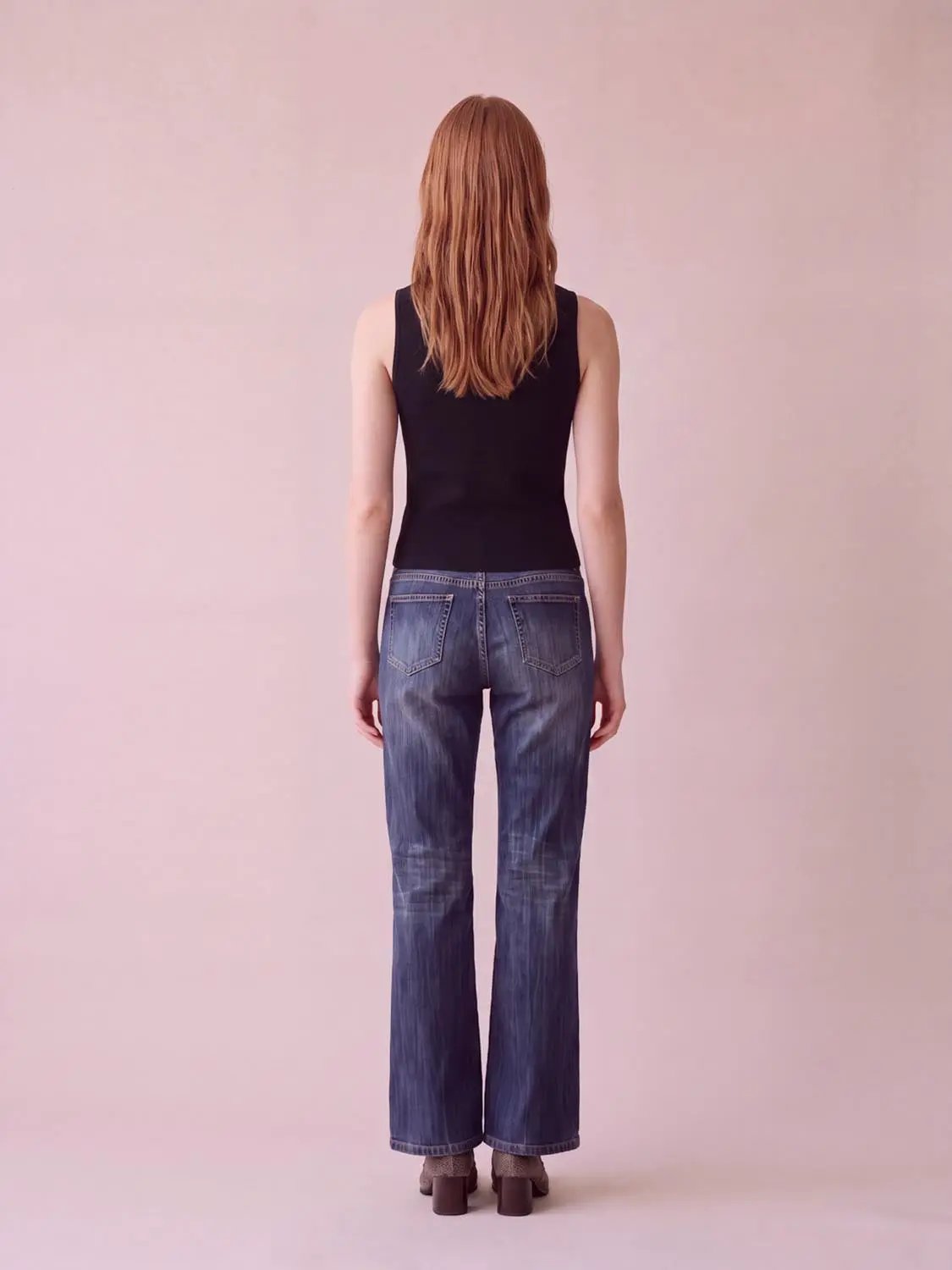 Round neck button-front sleeveless cropped knit vest in black.