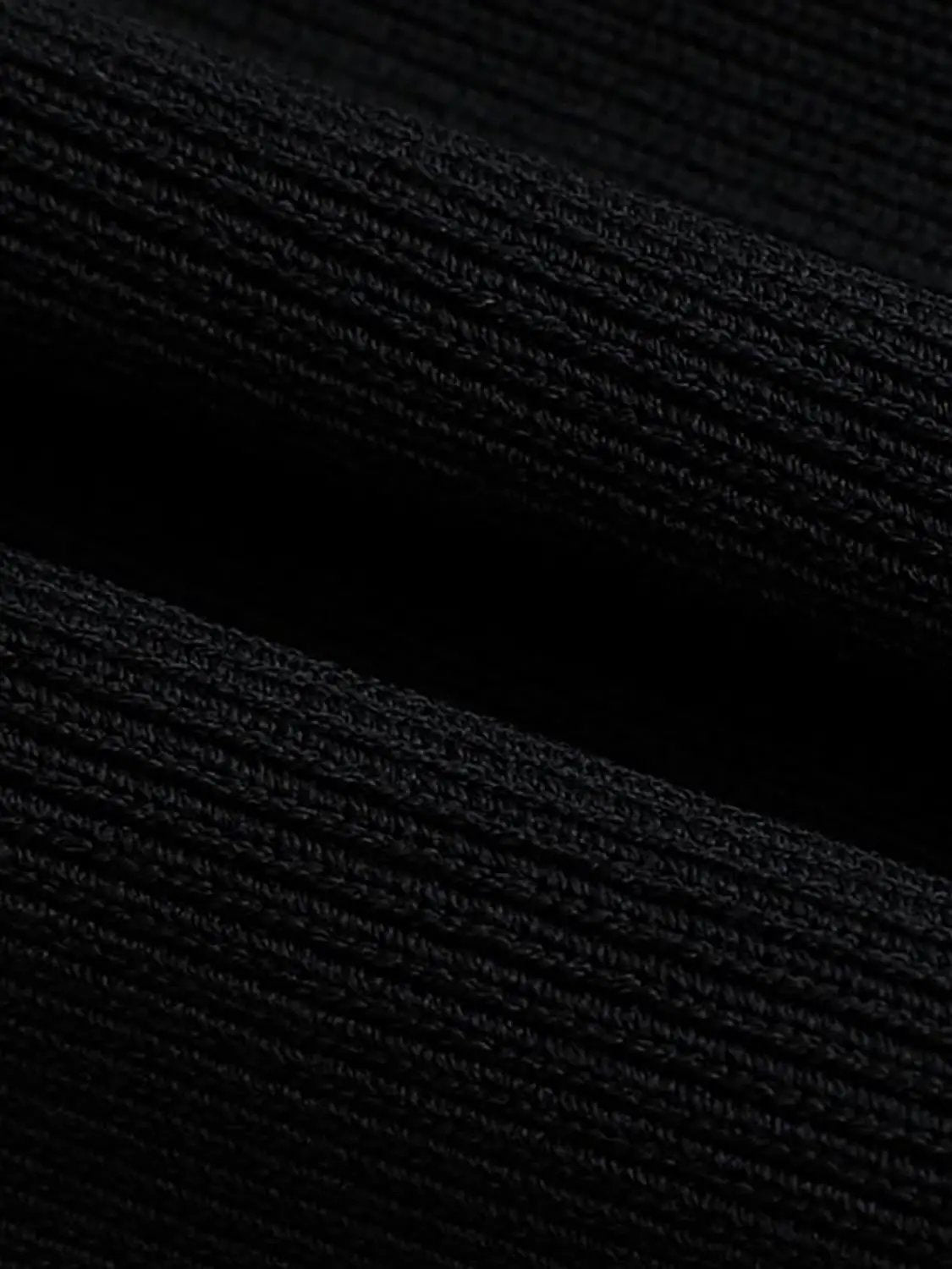 Round neck sleeveless cropped knit vest in black; close-up of textured knit fabric