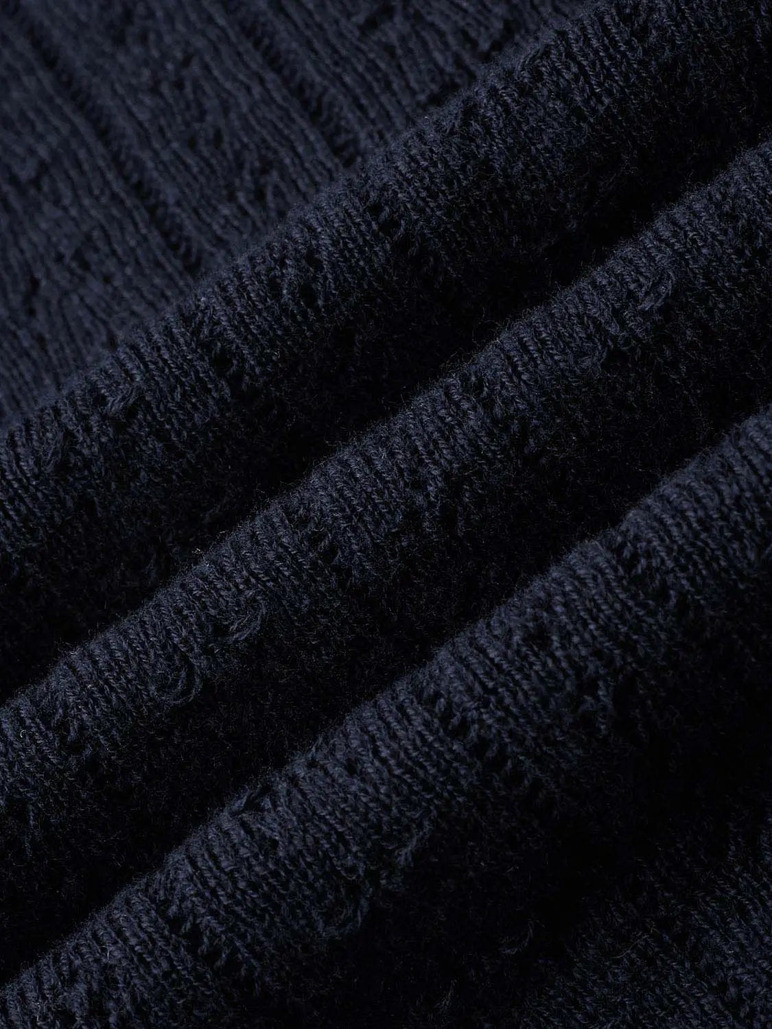 Cable-knit navy polo cotton shirt fabric close-up with ribbed texture