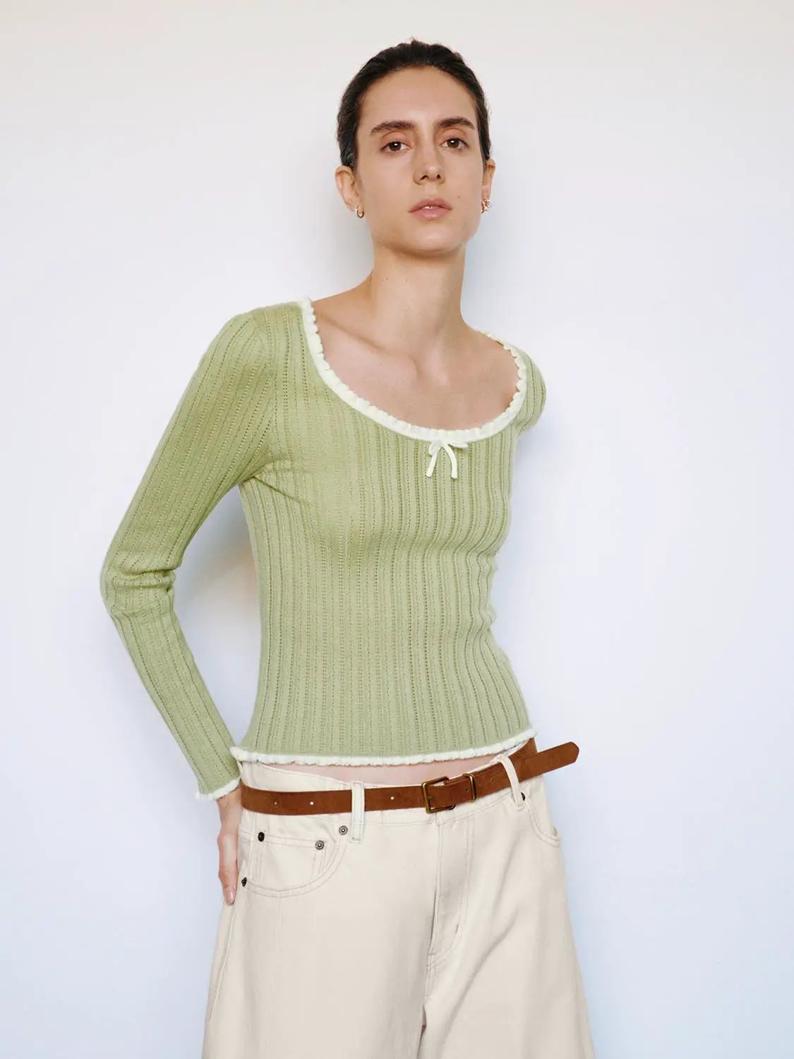 Ribbed knit long-sleeve T-shirt in sage green with square neckline, bow at front, and white trim.