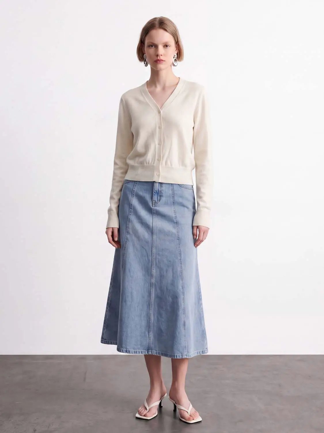 Knitted cardigan by Urban Revivo Fashion in cream knit, paired with a light-wash denim skirt