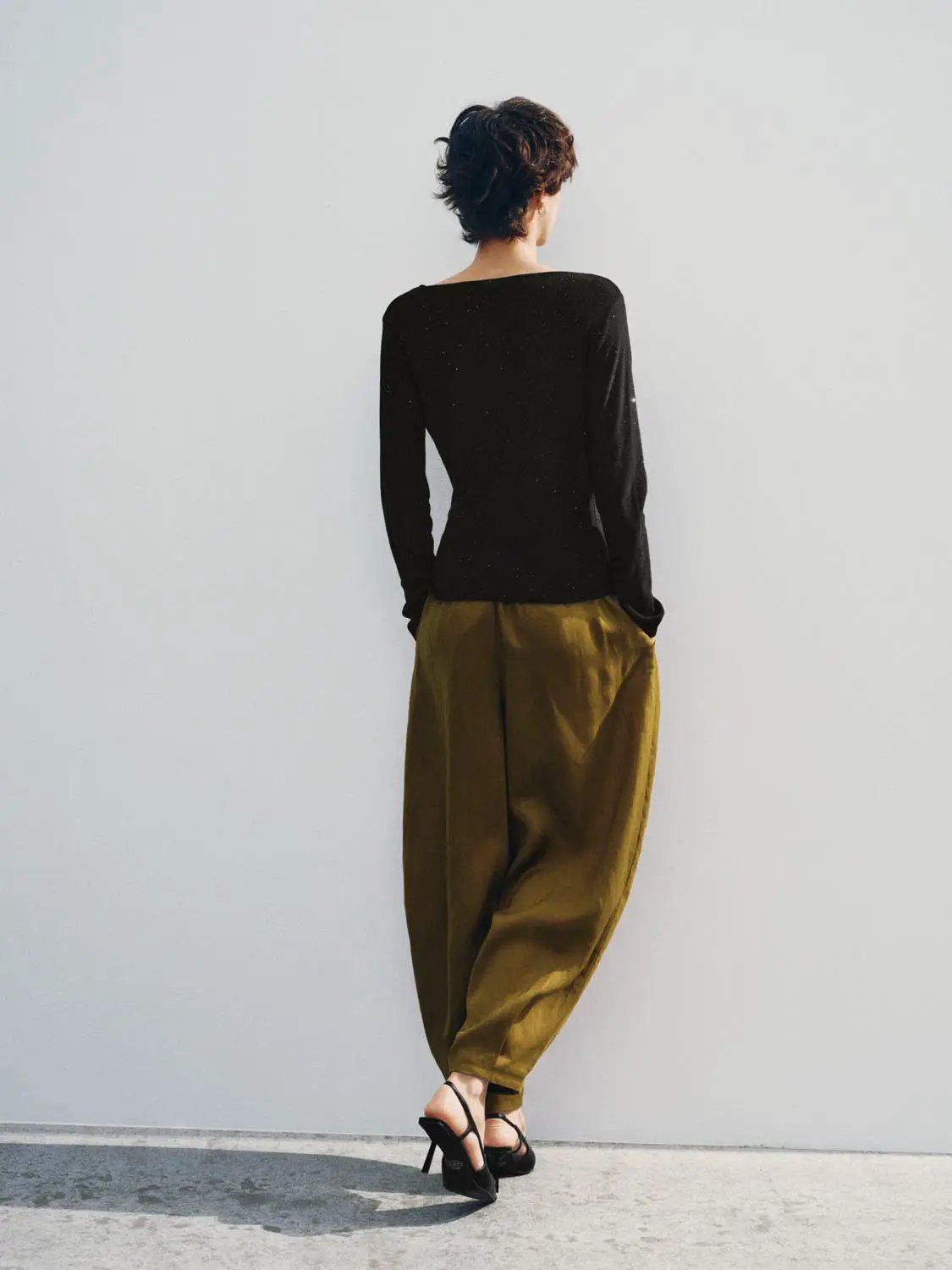 Knit T-Shirt in black, long-sleeve knitted top worn by a model with olive-brown trousers