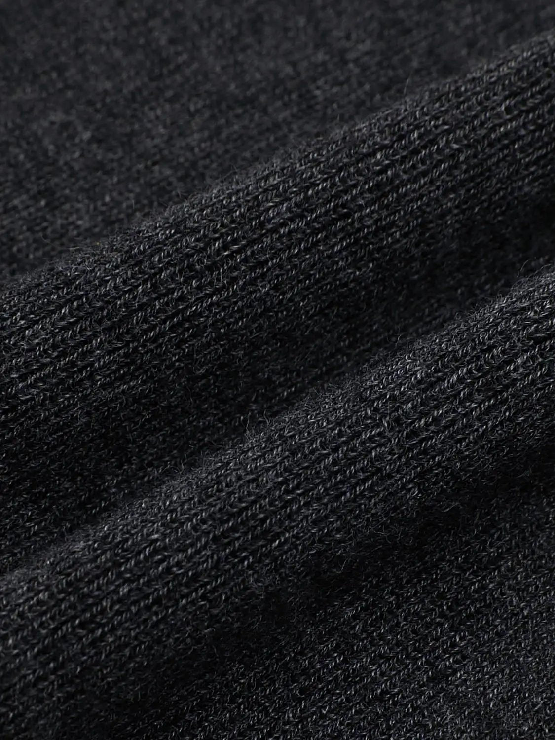 Ribbed black knit top, long-sleeve, close-up fabric texture.