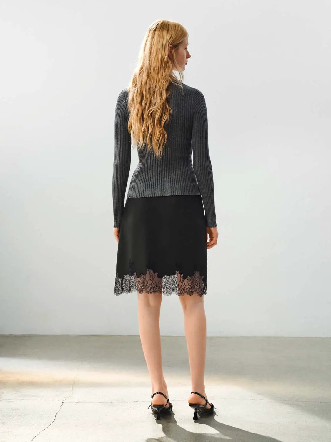 Fitted ribbed knit V-neck cardigan in grey worn with a black lace-hem skirt