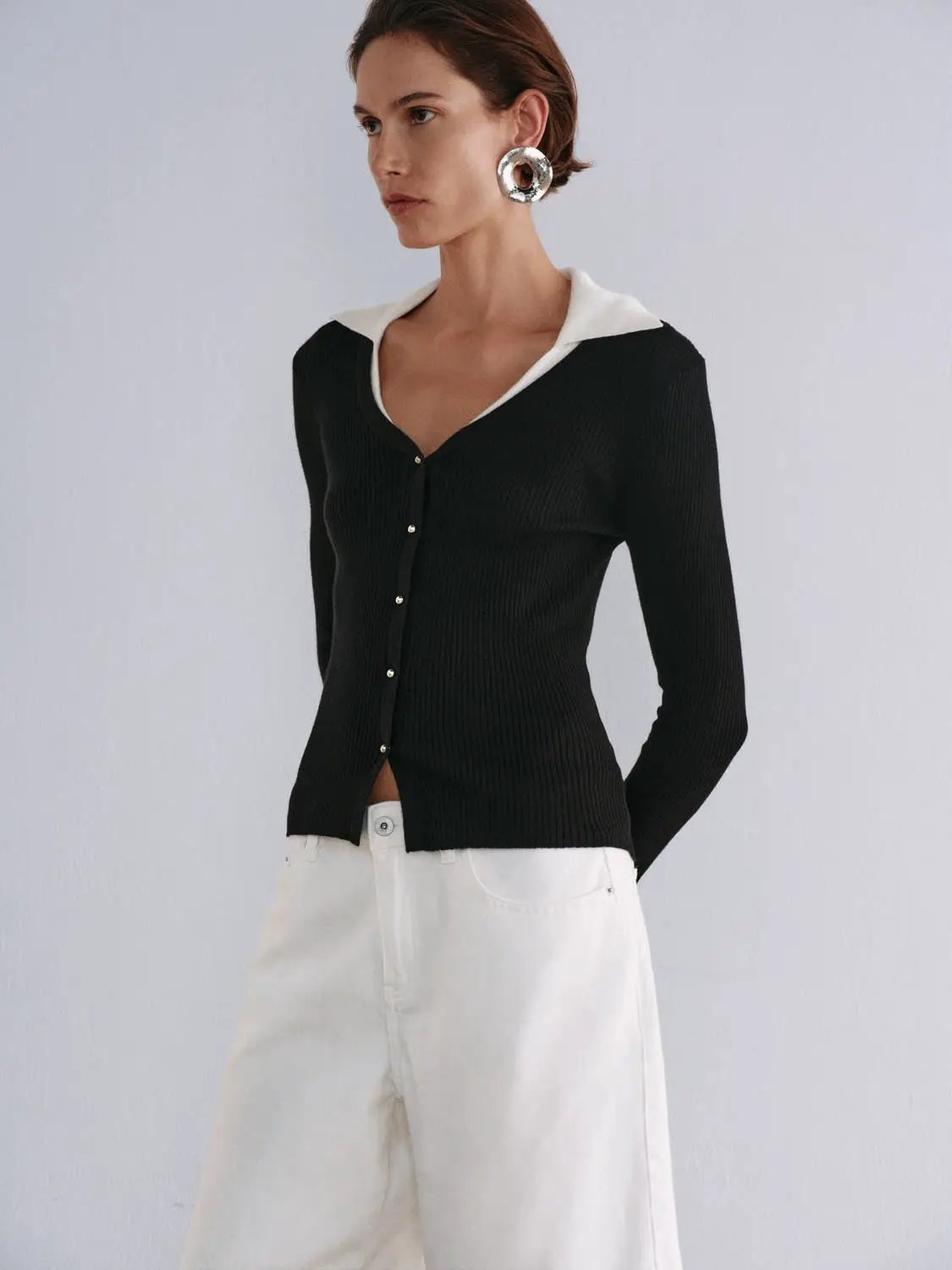 Knitted cardigan in black ribbed knit with white collar, button-down front.