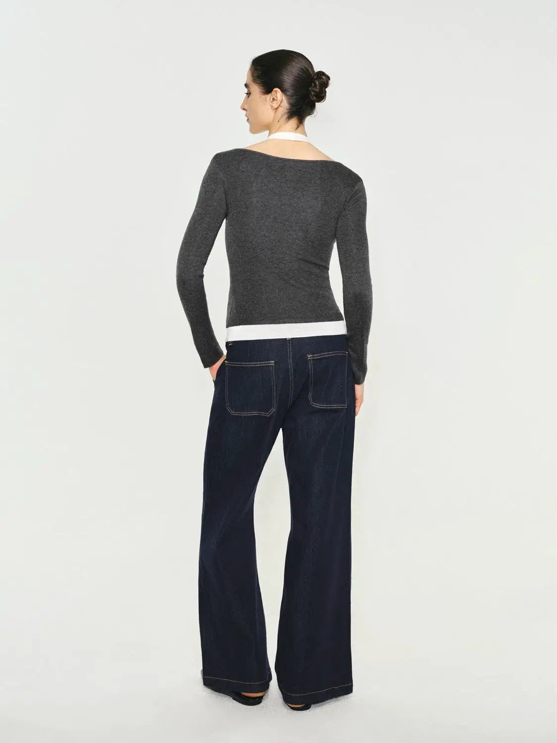 Fitted gray knit top with white contrast hem, boat neck and long sleeves, back view