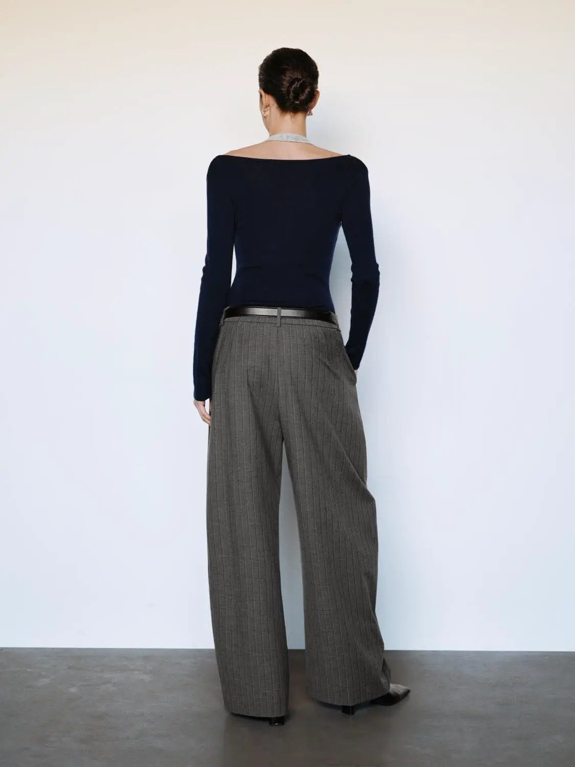 Fitted contrast-hem navy boat-neck long-sleeve knit top, paired with gray pinstripe wide-leg trousers