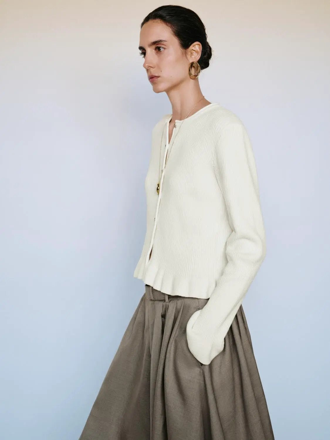 Ribbed heart-button crew-neck long-sleeve cardigan in cream knit worn with taupe skirt