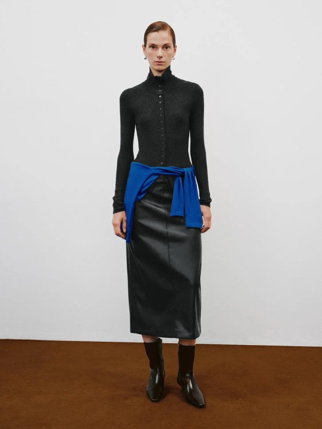 Ribbed slim mock-neck cardigan with button-front long sleeves; black with a blue sweater tied at the waist