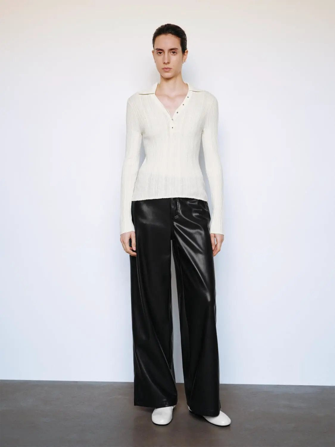 Ribbed fitted polo-collar long-sleeve sweater in cream, paired with black wide-leg pants.