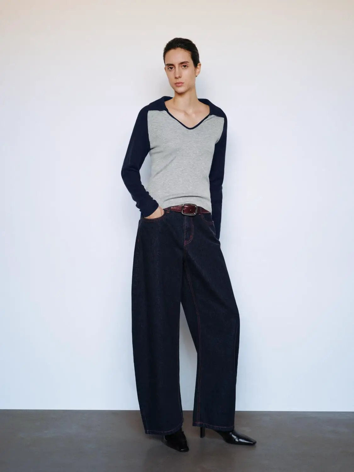 Fitted two-tone V-neck collared long-sleeve knit top, gray body with navy sleeves and navy trim.