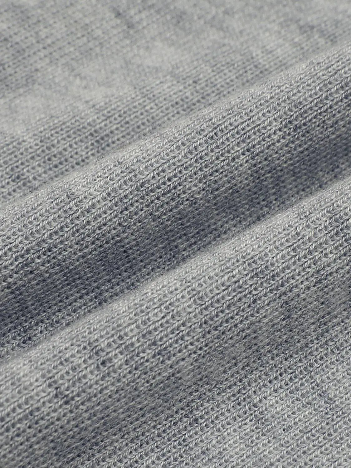 Fitted two-tone gray knit top with long sleeves; close-up textured fabric