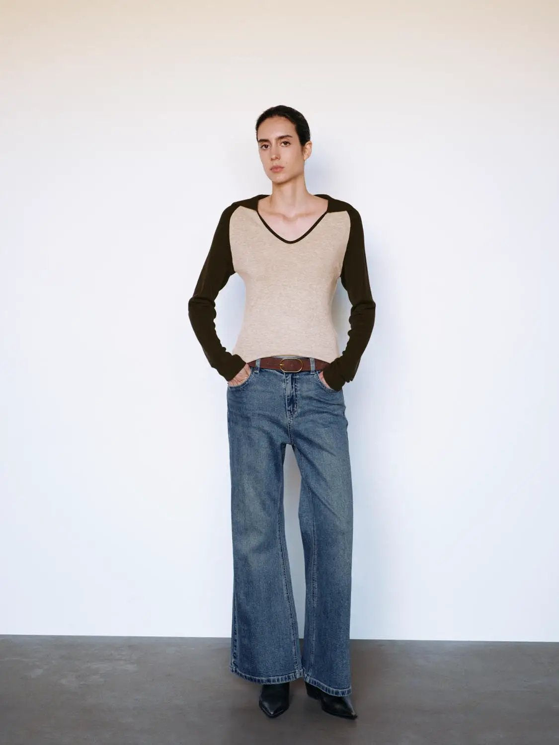 Fitted two-tone V-neck long-sleeve knit top with beige body and black sleeves