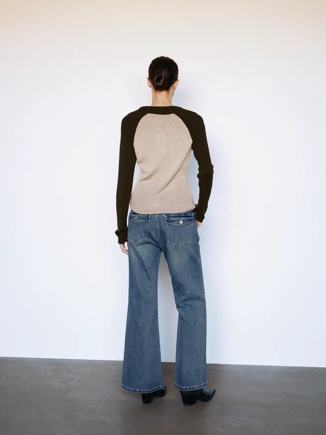 Fitted two-tone long-sleeve knit top with beige body and dark sleeves