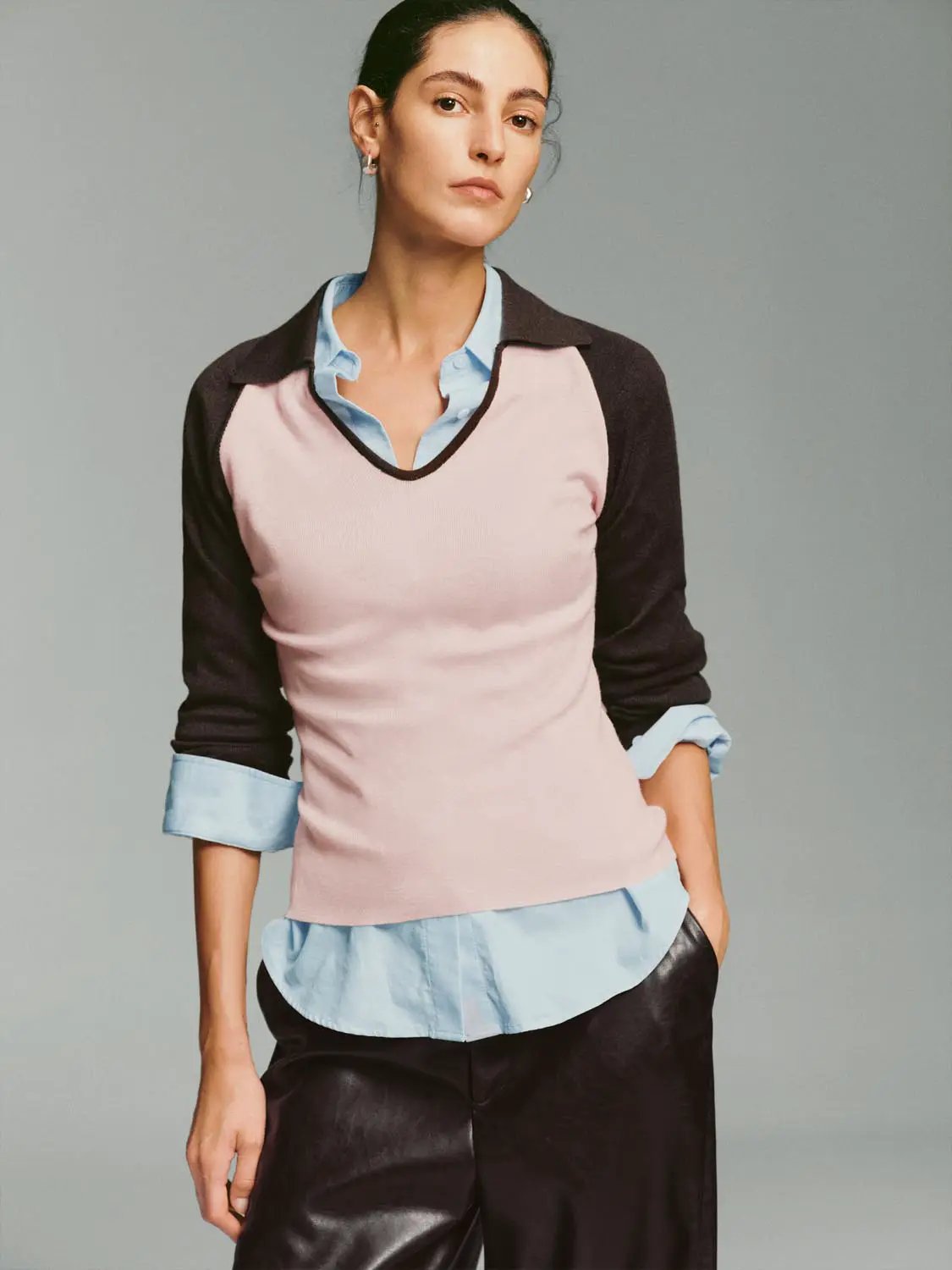 Fitted two-tone V-neck collared knit top; pink body, dark sleeves, light blue collar and cuffs.