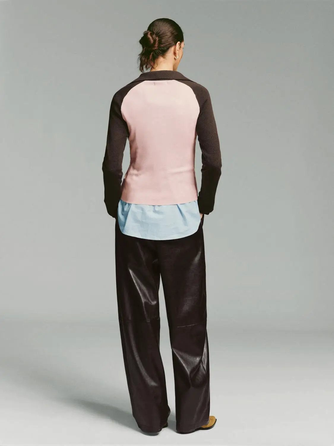 Fitted two-tone V-neck collared long-sleeve knit top, pink body with dark brown sleeves and light blue hem.