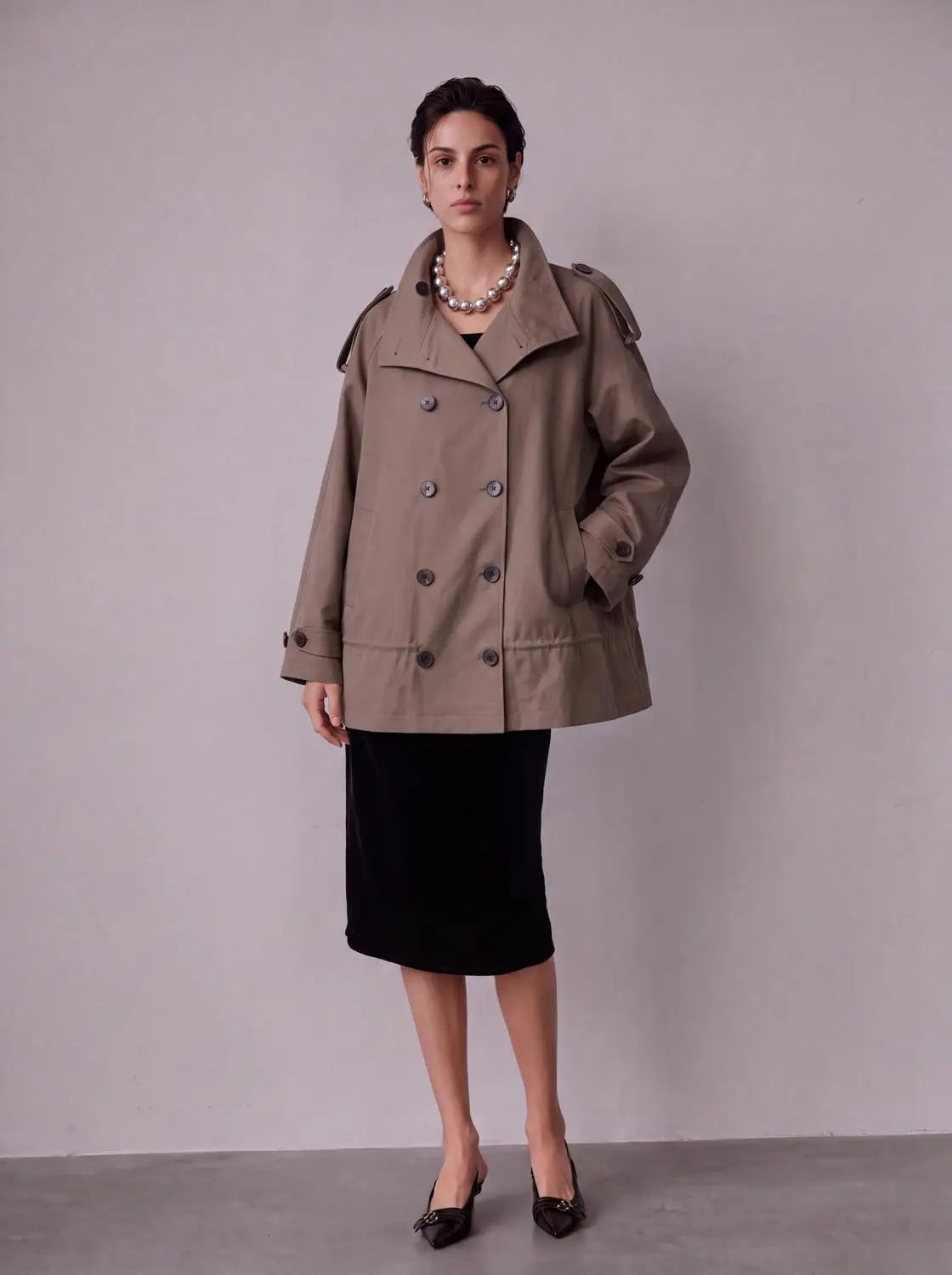Trench coat taupe, double-breasted with wide lapels and shoulder epaulets, on model