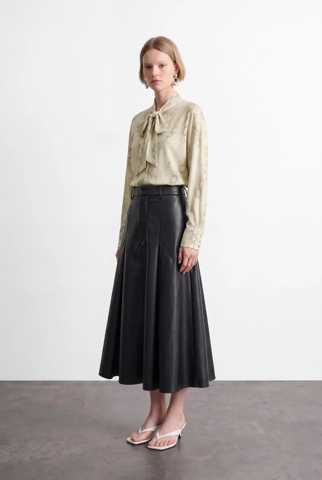 Pleated vegan-leather A-line skirt in black, midi length