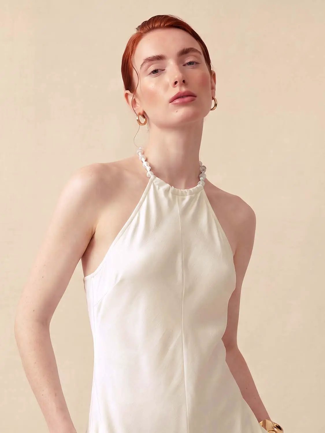 A-Line dress, white halter-neck with beaded neckline, worn by model