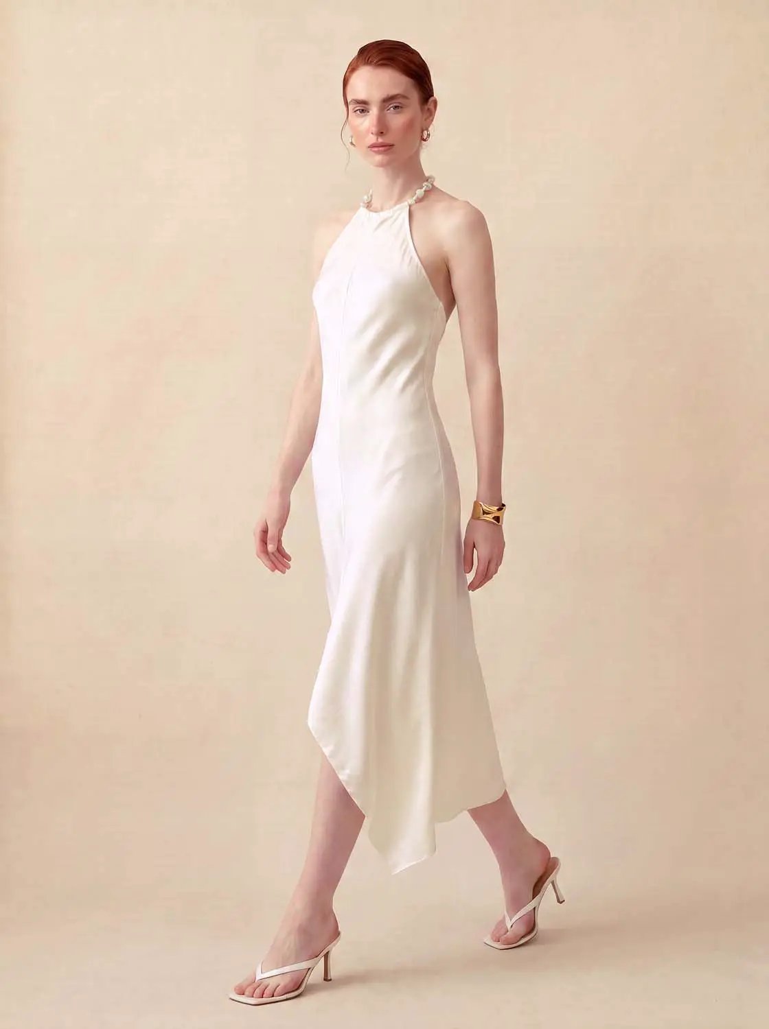 A-line dress in ivory satin with halter neck and asymmetric hem