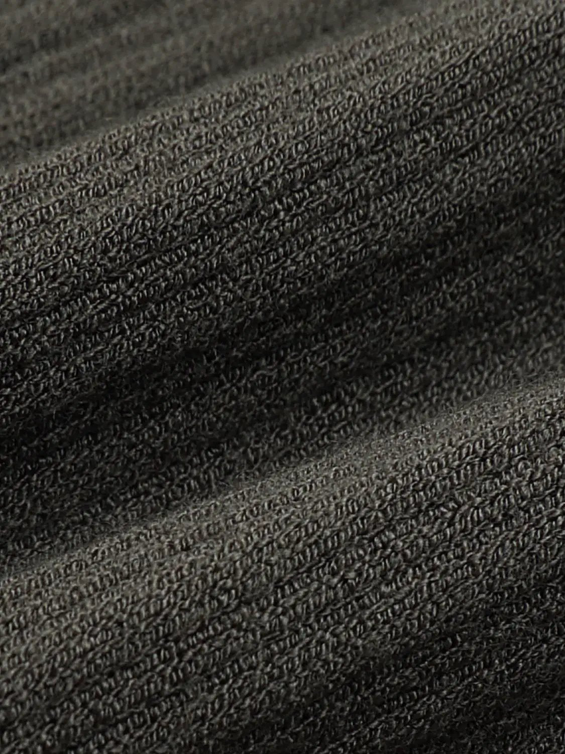 Knit T‑Shirt fabric in dark gray knitted texture, close-up