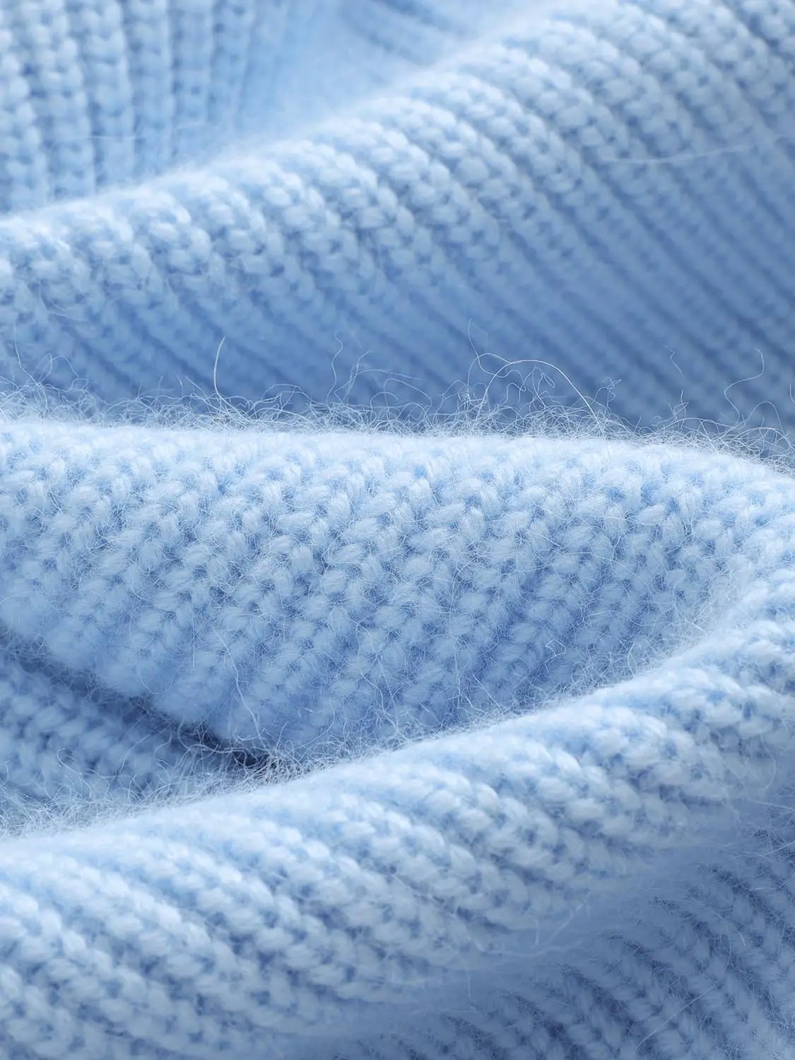 Knit jacket fabric close-up in light blue knitted yarn.
