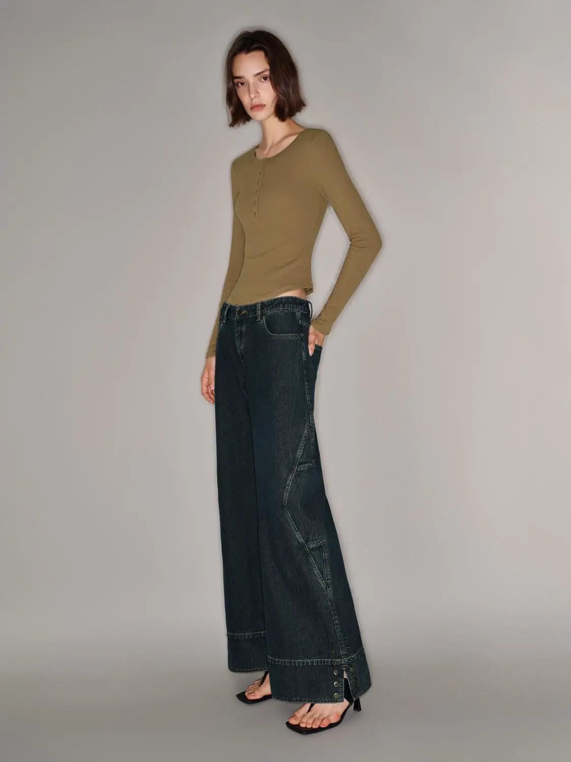 T-Shirt in olive long-sleeve Henley style with button placket, paired with dark denim wide-leg jeans.