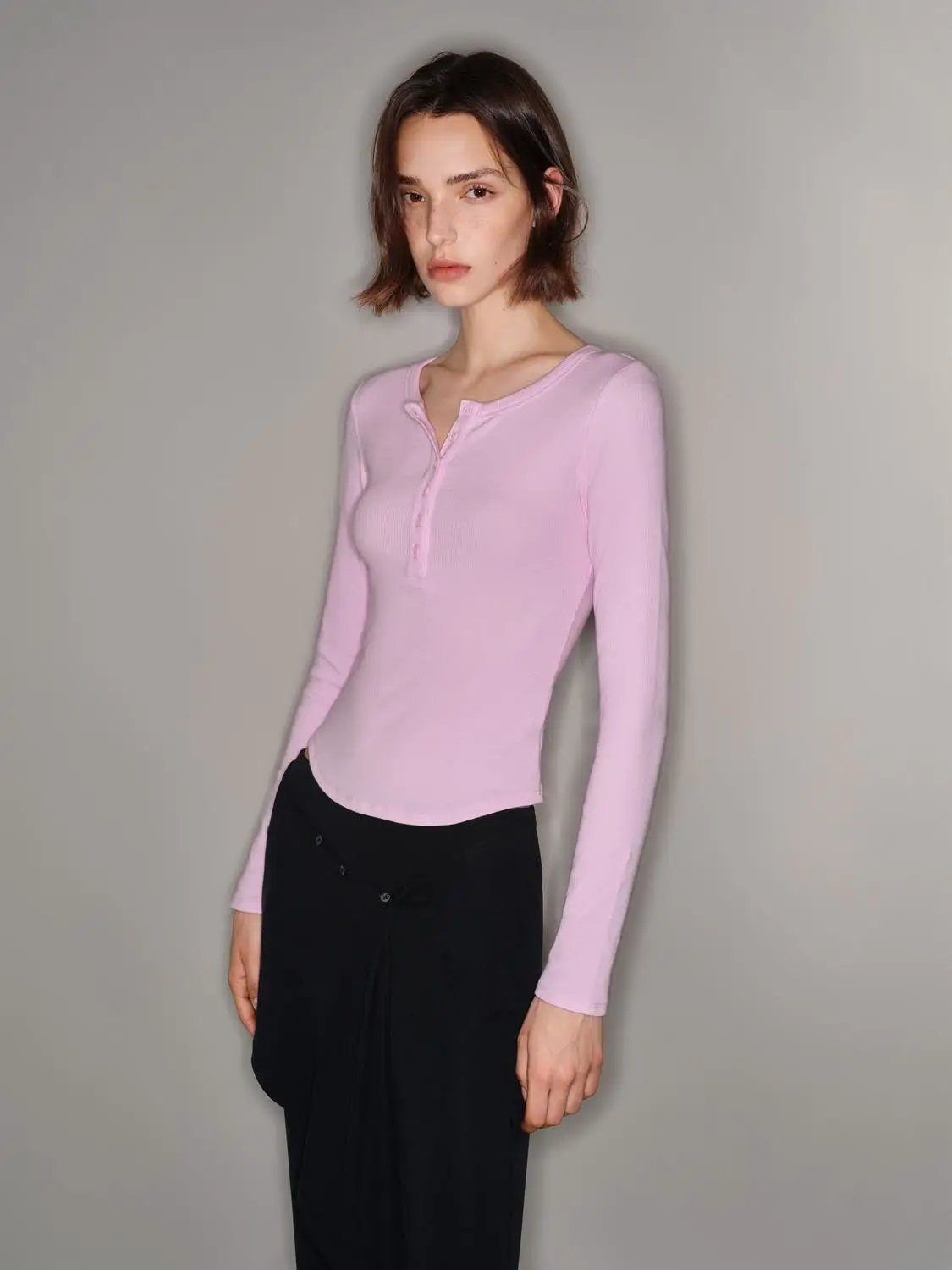 T-Shirt in pastel pink ribbed knit, long sleeves with Henley button placket on model