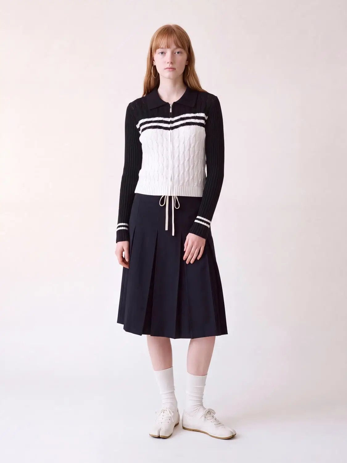 Striped collared knitted cardigan, black sleeves with white front panel, zip front, cropped to waist.