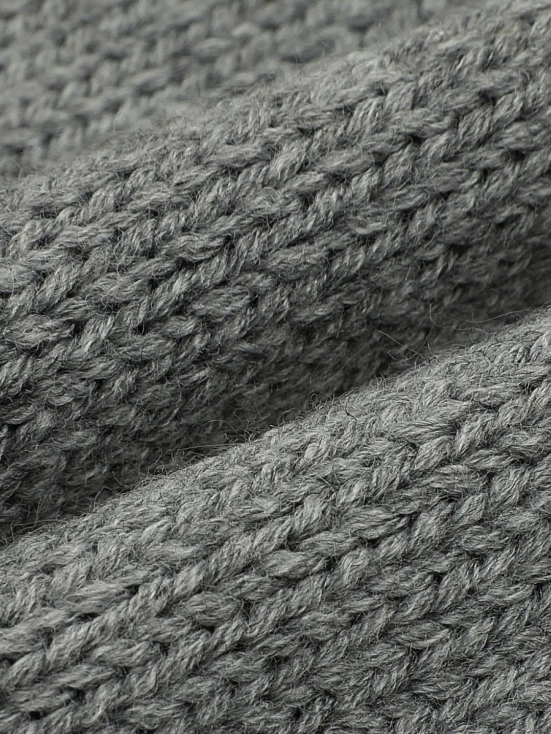 Knitted cardigans gray fabric close-up with chunky knit texture