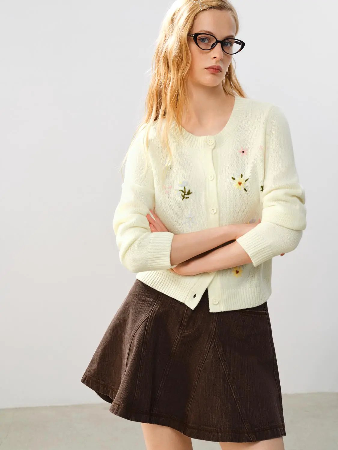 Cream knitted cardigan with floral embroidery and button front.