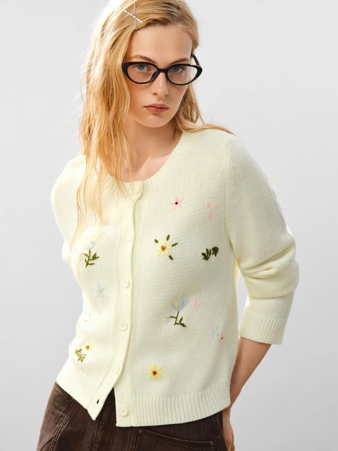 Knitted cardigan in pale yellow with embroidered floral details.