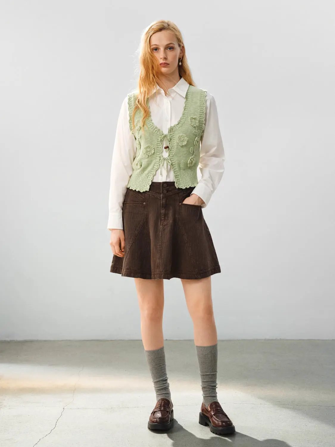 Floral Ruffle Tie V-neck Sleeveless Cotton Vest in light green worn with white blouse and brown skirt