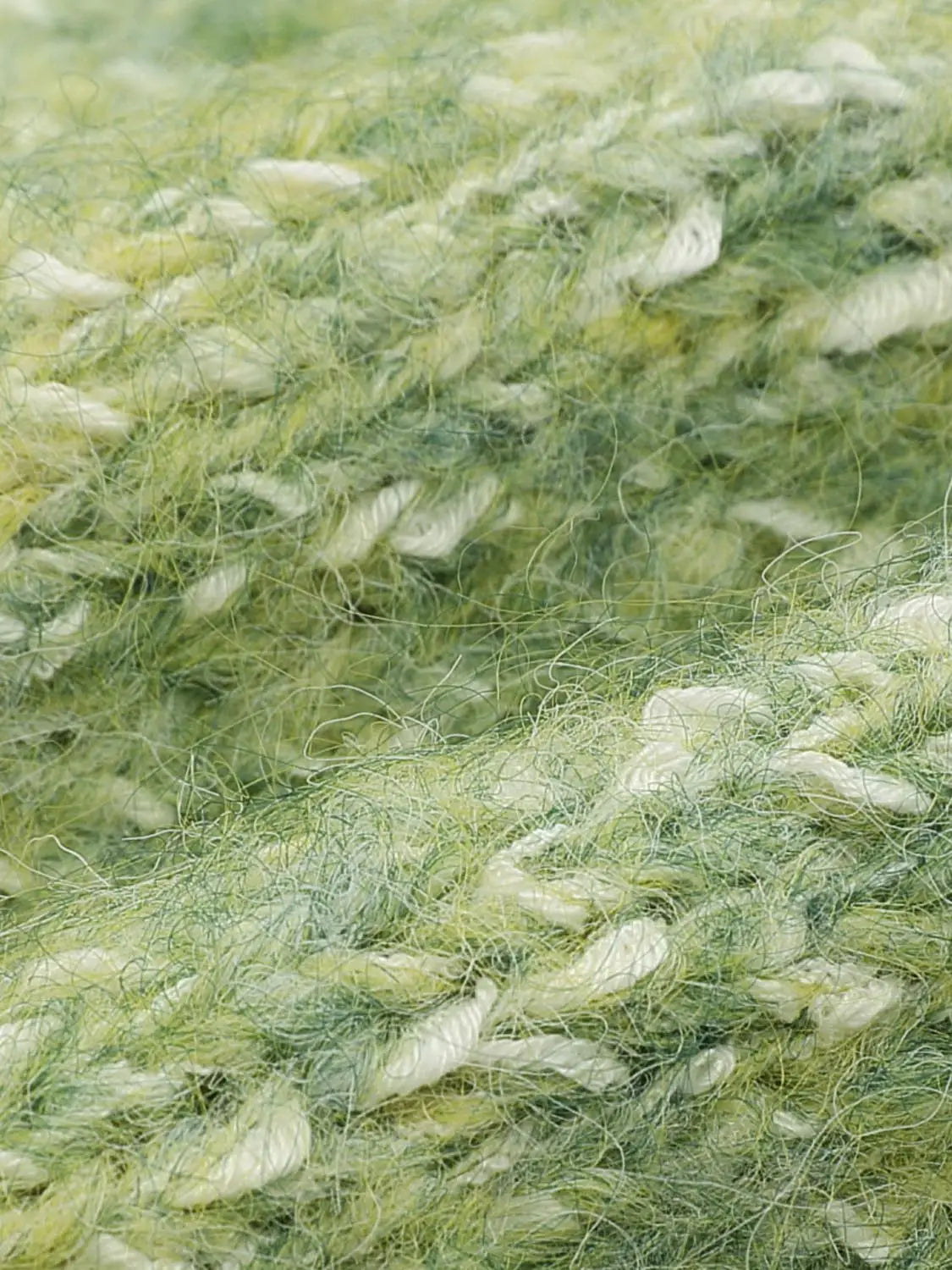 Knit cardigan yarn close-up in green and pale yellow tones