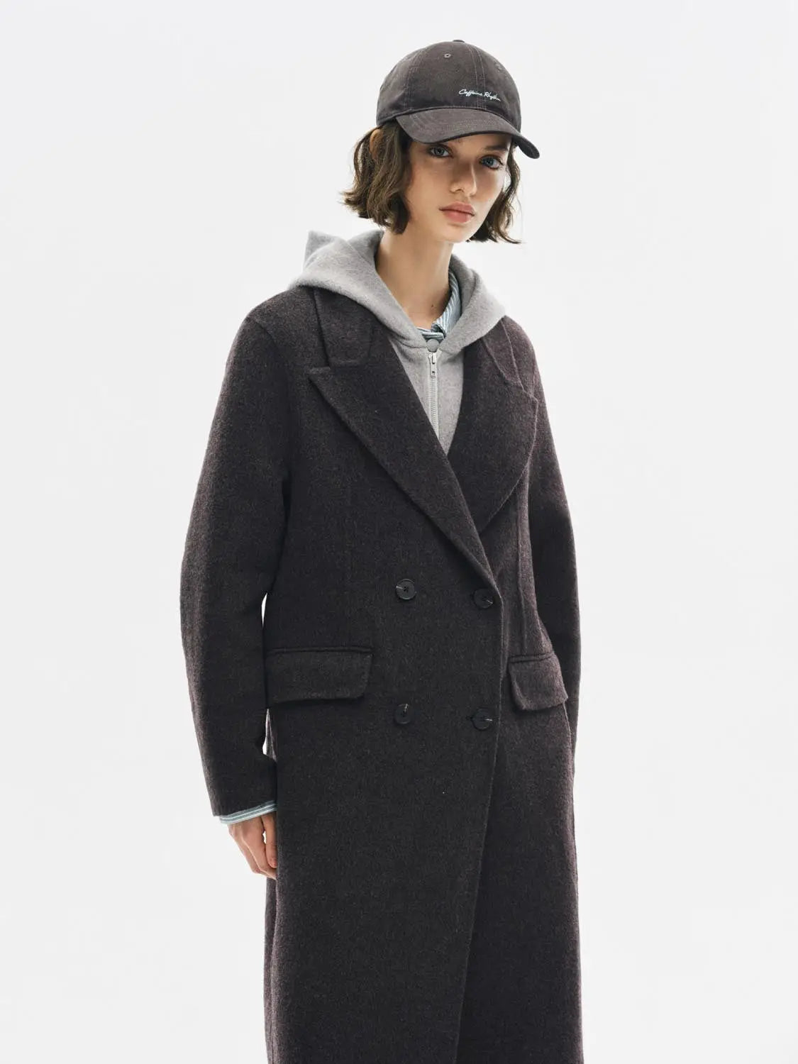 Coat by Urban Revivo Fashion; dark charcoal double-breasted wool coat with wide lapels worn over a grey hoodie.