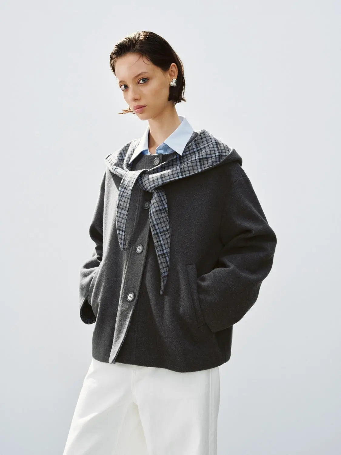 Coat in dark gray wool with plaid scarf over white pants