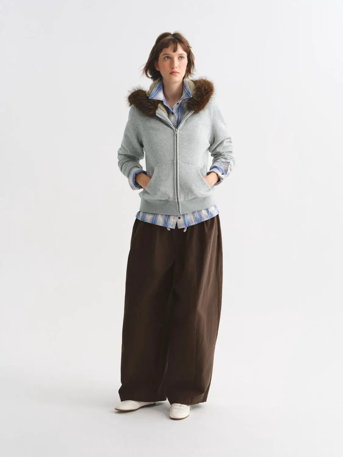 Other jackets gray zip-up with brown fur collar worn by model.