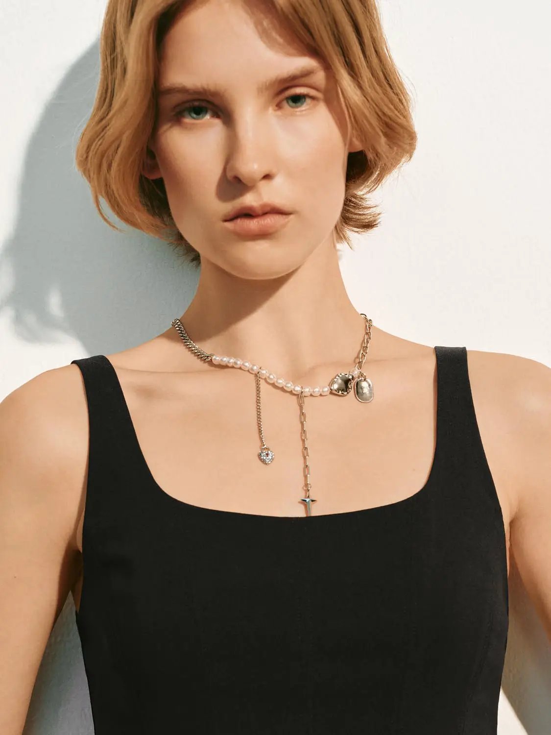 Black A-line sleeveless square-neck dress worn by model; minimalist and elegant
