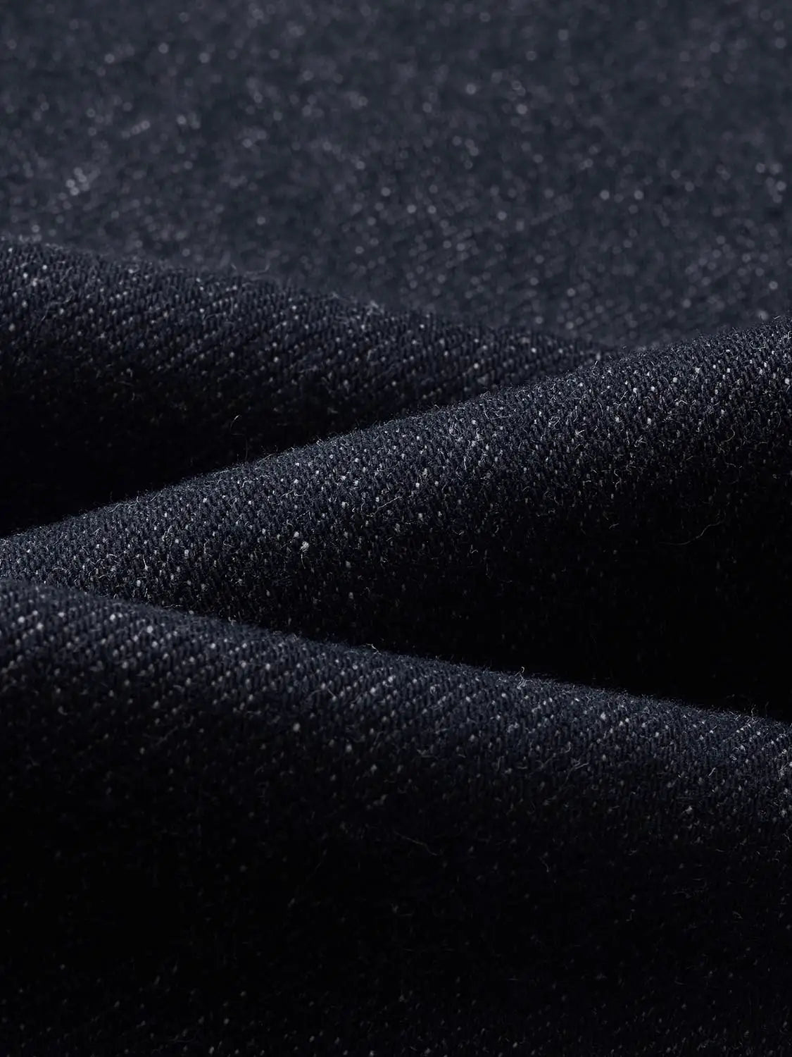 Jeans dark indigo denim fabric close-up with subtle textured weave