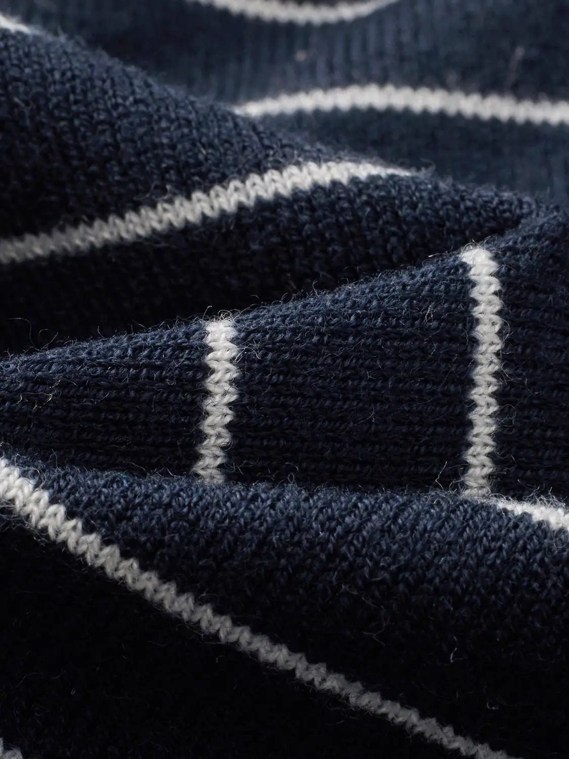 Knit cardigan in navy with white stripe detailing; textured knit fabric.