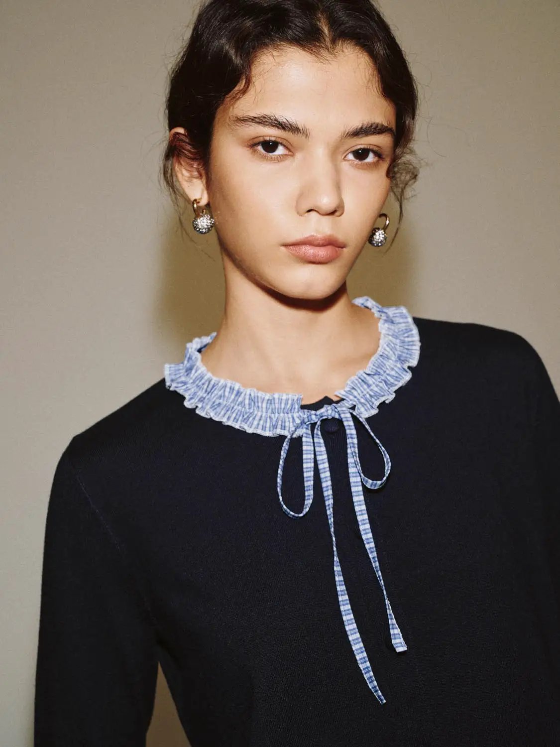 Knitted cardigan in navy with a blue gingham ruffled collar and ties.